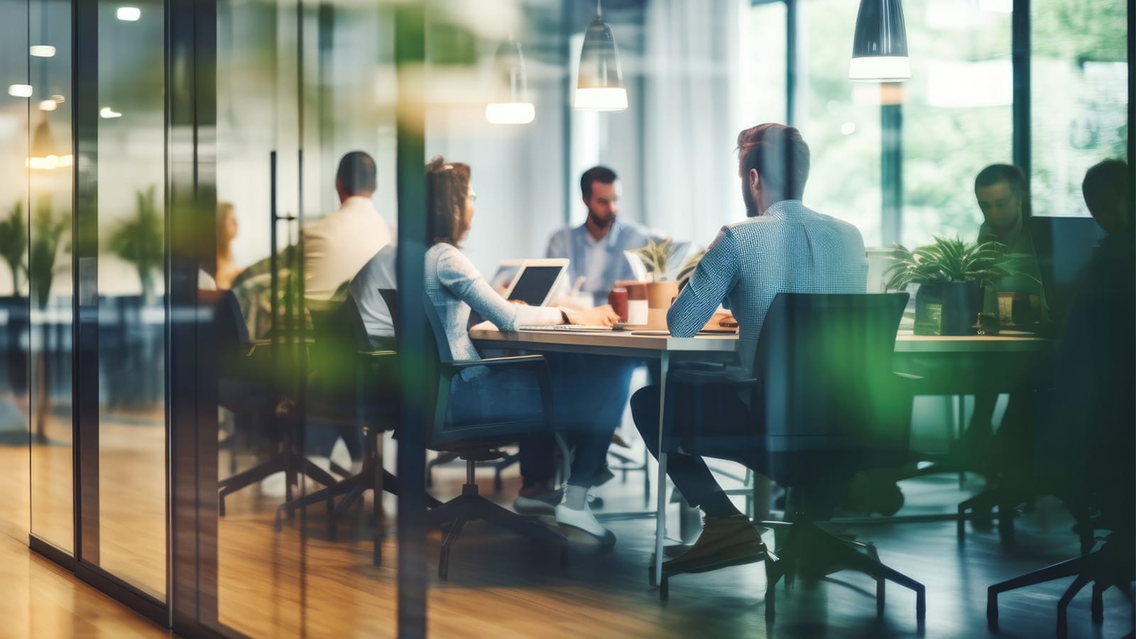 Kolleger som sitter i et møterom. Foto: Adobe Stock